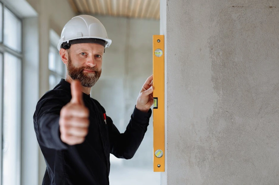 Uśmiechnięty student z laptopem pokazujący kciuk w górę